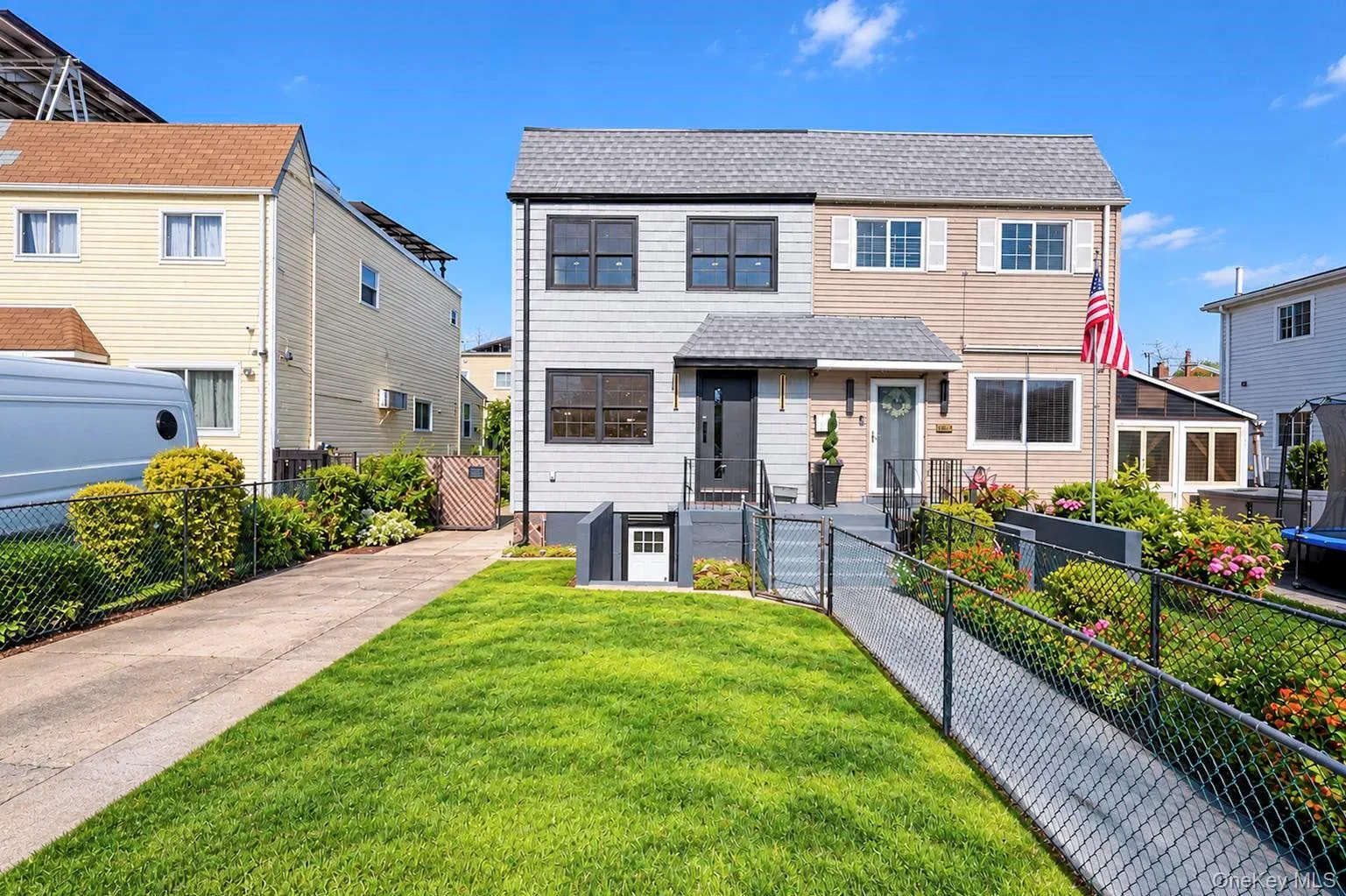 Two-story facade with mixed siding, an integrated ramp, and a well-maintained lawn Two-story facade with mixed siding, an integrated ramp, and a well-maintained lawn