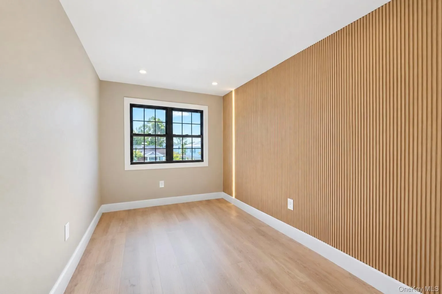 Wood-finish flooring, recessed lighting, and a window with black trim. Wood-finish flooring, recessed lighting, and a window with black trim.
