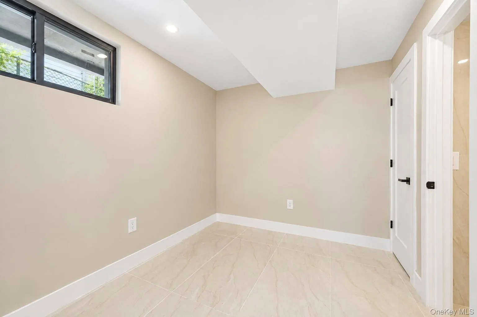 Recessed lighting, light-toned wall finishes, tiled flooring, white trim, and a white interior door with black hardware. Recessed lighting, light-toned wall finishes, tiled flooring, white trim, and a white interior door with black hardware.