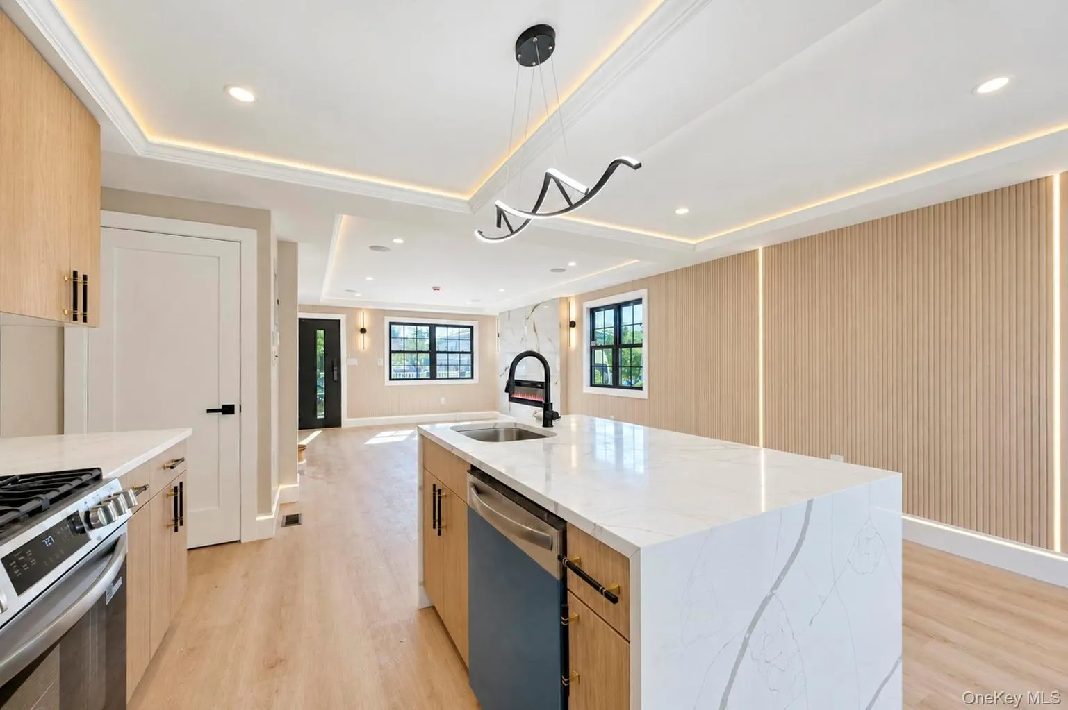 Gourmet kitchen featuring a waterfall island with a vessel sink, stainless steel appliances, and wood-finish cabinetry, Gourmet kitchen featuring a waterfall island with a vessel sink, stainless steel appliances, and wood-finish cabinetry,