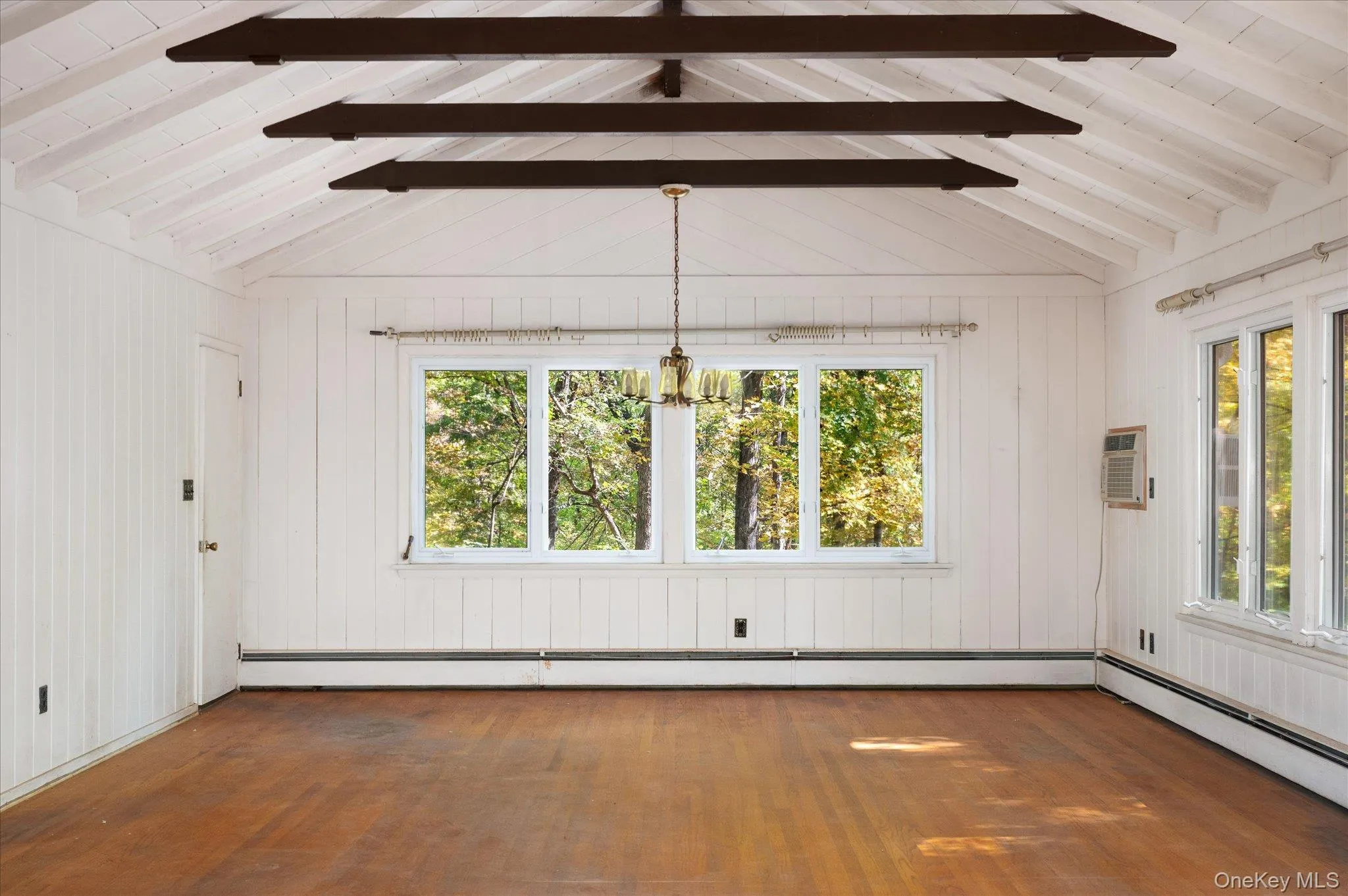 Dining area at the far end of the great room, framed by windows Dining area at the far end of the great room, framed by windows