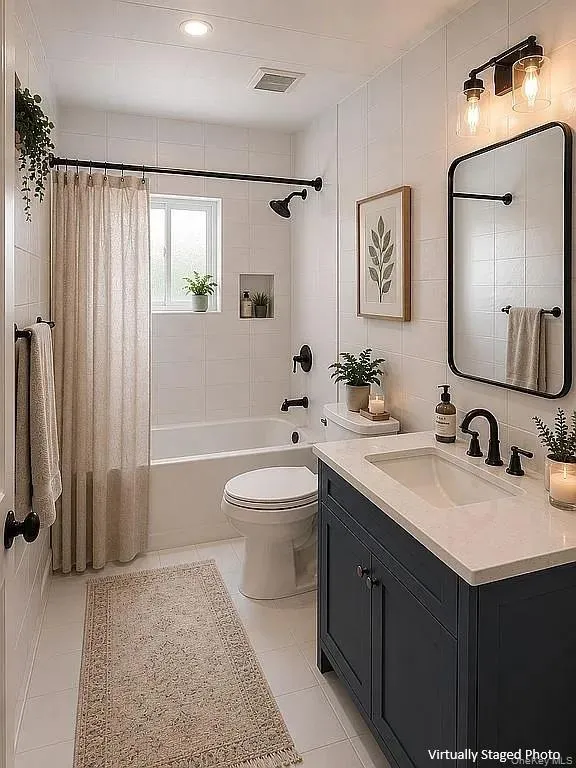 Bathroom featuring a navy vanity cabinet with a light-toned countertop, rectangular wall-mounted mirror with a black frame, recessed wall niche, and matte black plumbing fixtures Bathroom featuring a navy vanity cabinet with a light-toned countertop, rectangular wall-mounted mirror with a black frame, recessed wall niche, and matte black plumbing fixtures