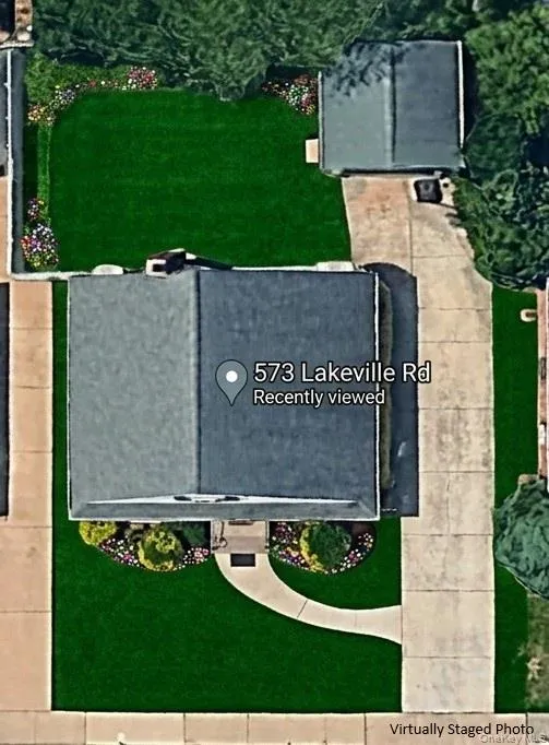 Aerial view featuring a detached garage, and a concrete driveway Aerial view featuring a detached garage, and a concrete driveway