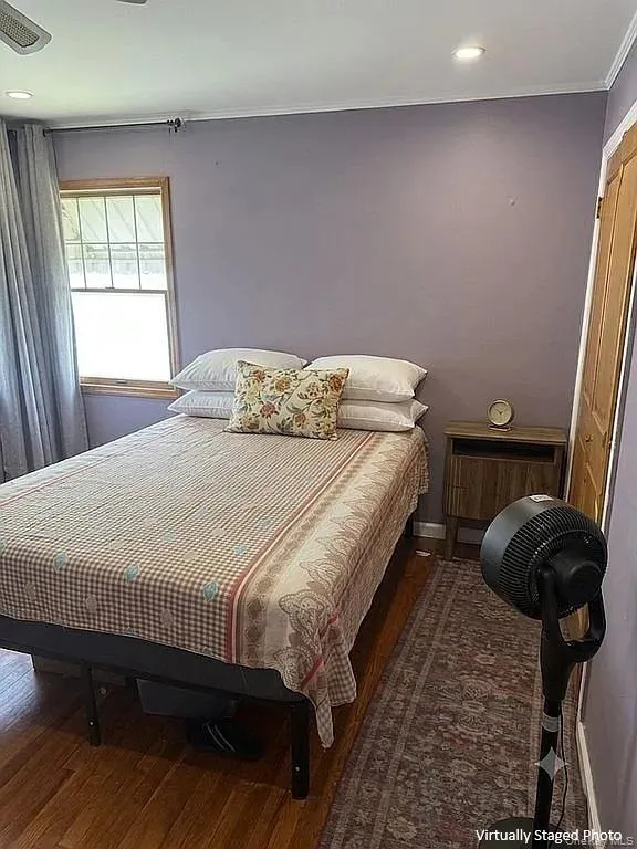Wood-finish flooring, recessed lighting, and a single-hung window with natural wood trim Wood-finish flooring, recessed lighting, and a single-hung window with natural wood trim