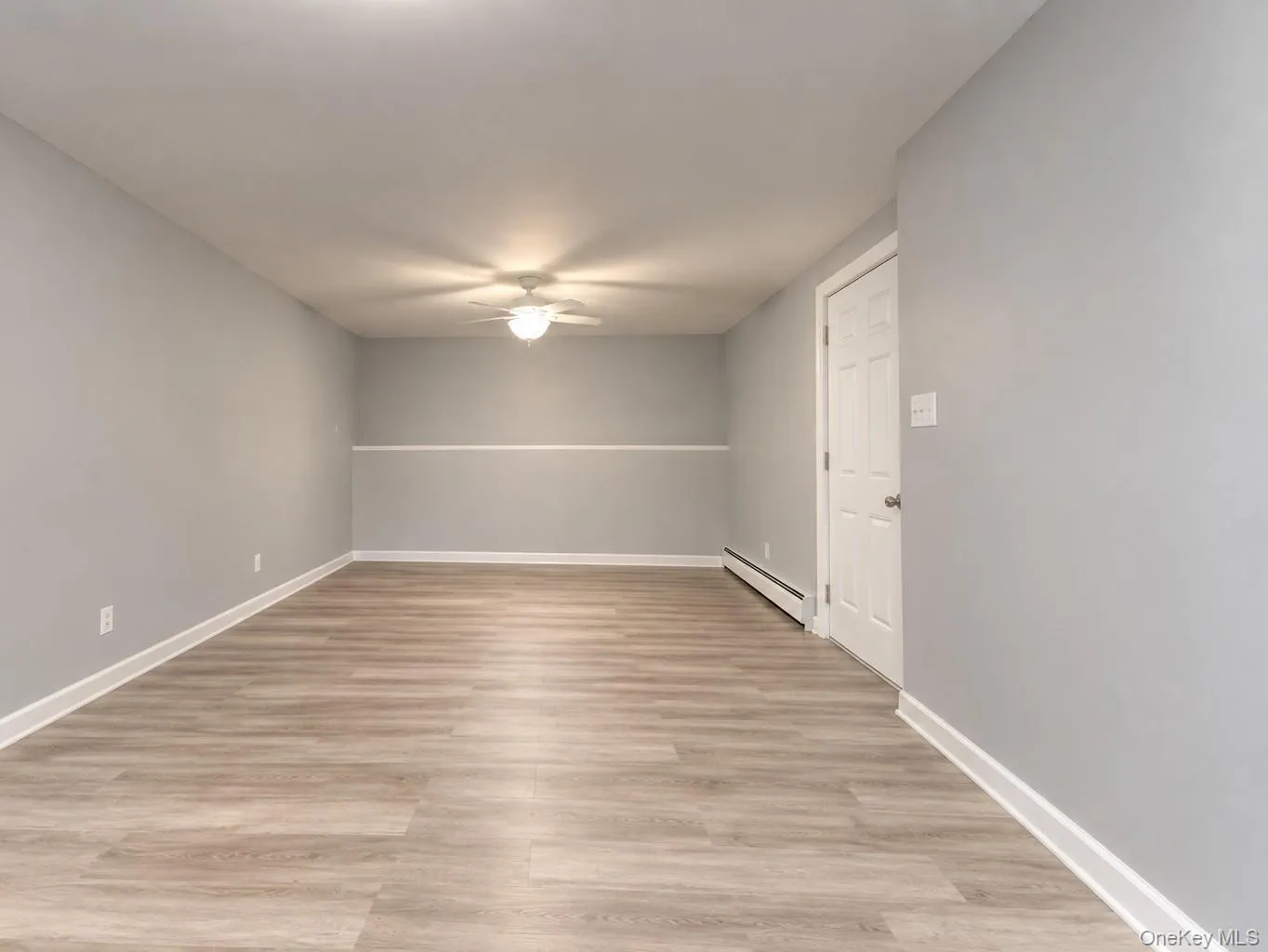 Spacious finished room featuring light gray walls, wide-plank vinyl flooring, and crisp white trim for a clean, modern look. The ceiling fan with integrated light adds comfort and efficiency, while the neutral palette makes this space ideal for use as a home office, guest room, or recreation area. Bright, open, and move-in ready — a versatile extension of the home’s living space. Spacious finished room featuring light gray walls, wide-plank vinyl flooring, and crisp white trim for a clean, modern look. The ceiling fan with integrated light adds comfort and efficiency, while the neutral palette makes this space ideal for use as a home office, guest room, or recreation area. Bright, open, and move-in ready — a versatile extension of the home’s living space.
