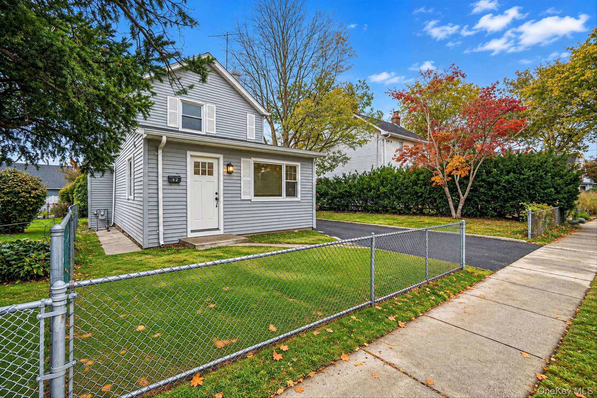 Two-story vinyl-sided exterior featuring white shutters, an asphalt driveway, and a chain-link fence *virtually edited Two-story vinyl-sided exterior featuring white shutters, an asphalt driveway, and a chain-link fence *virtually edited