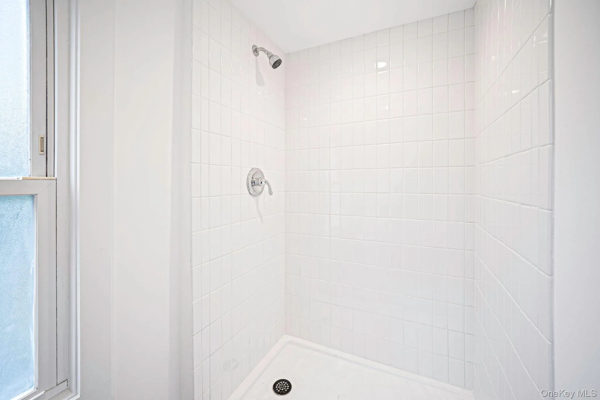 Second floor shower stall featuring white square tile surround, white basin, and polished chrome fixtures Second floor shower stall featuring white square tile surround, white basin, and polished chrome fixtures