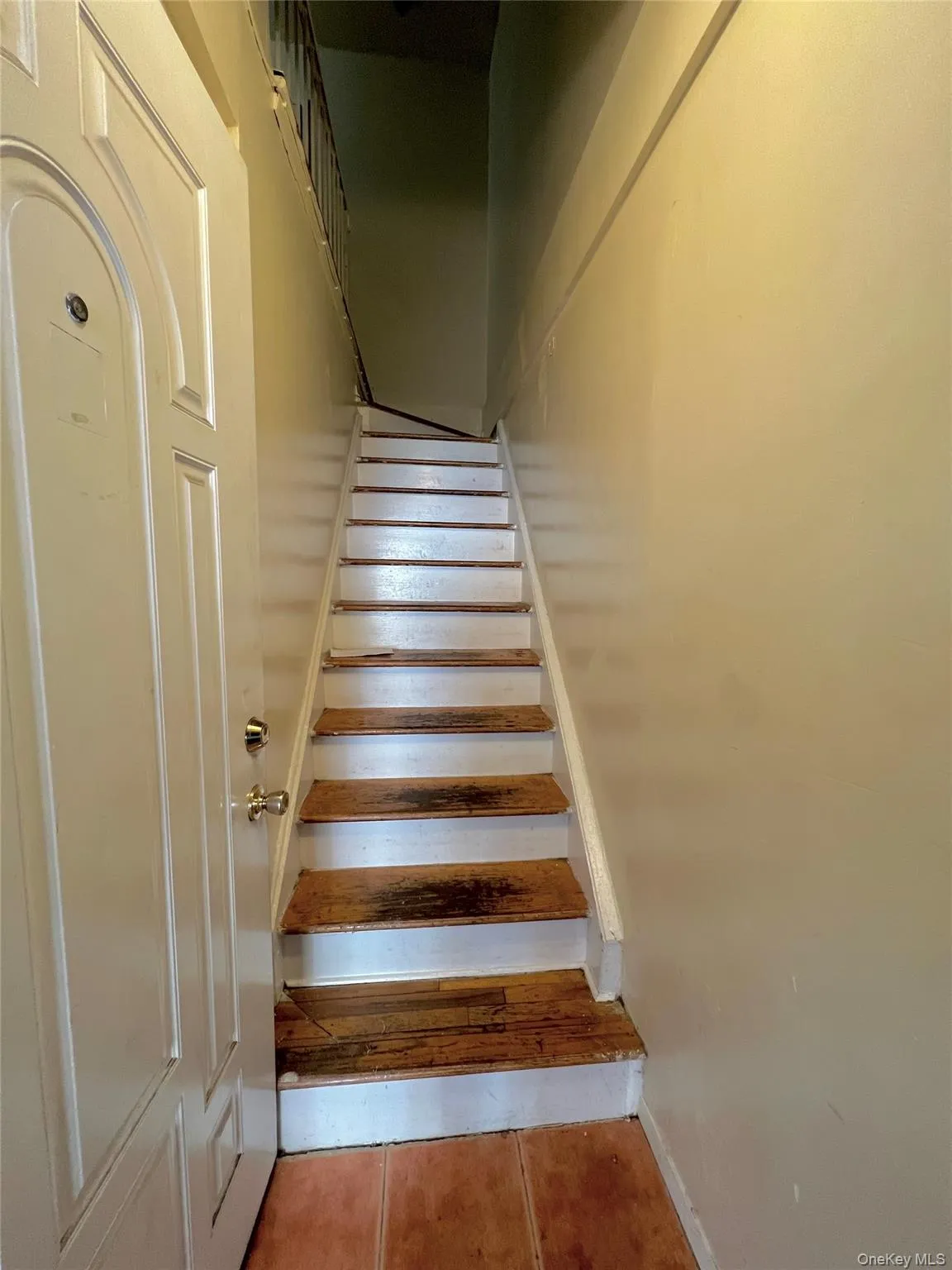 Stairway featuring tile patterned floors and baseboards Stairway featuring tile patterned floors and baseboards