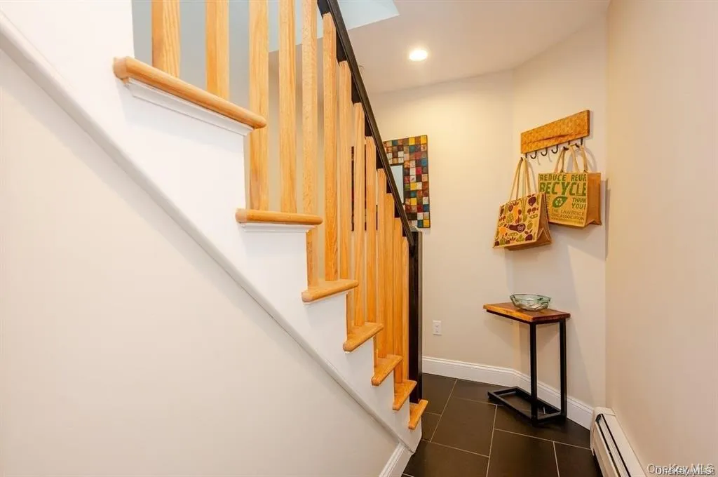Staircase featuring baseboard heating, tile patterned flooring, and recessed lighting Staircase featuring baseboard heating, tile patterned flooring, and recessed lighting