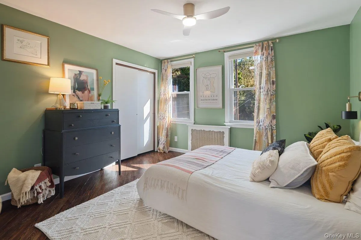 The warm and welcoming primary bedroom, with windows facing the front of the house, features wood floors, a new ceiling fan, and multiple closets. The warm and welcoming primary bedroom, with windows facing the front of the house, features wood floors, a new ceiling fan, and multiple closets.