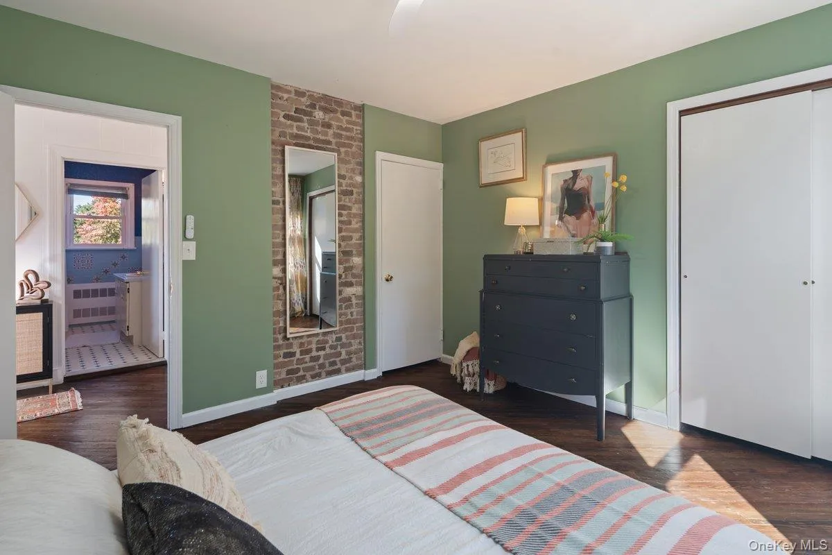 A brick accent wall is one of the original details that adds charm to the primary bedroom. The full bath is across the hall. A brick accent wall is one of the original details that adds charm to the primary bedroom. The full bath is across the hall.