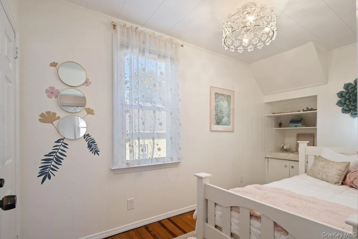 The charming third bedroom faces the side yard, featuring original built-in shelves, a full closet, and a new novelty fandolier. The charming third bedroom faces the side yard, featuring original built-in shelves, a full closet, and a new novelty fandolier.
