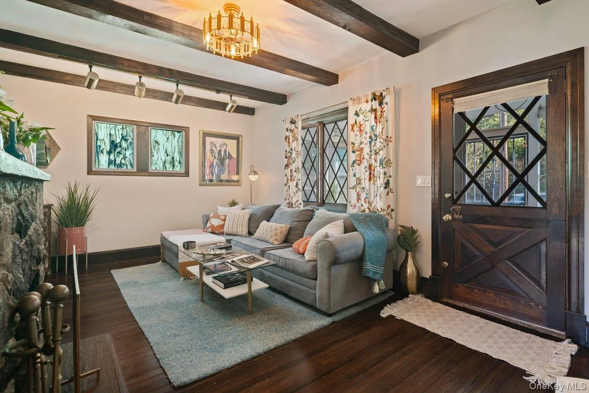Additional view of the living room highlighting the wood beam ceiling, Dutch wood door, side window w privacy glass, and large picture window. Additional view of the living room highlighting the wood beam ceiling, Dutch wood door, side window w privacy glass, and large picture window.