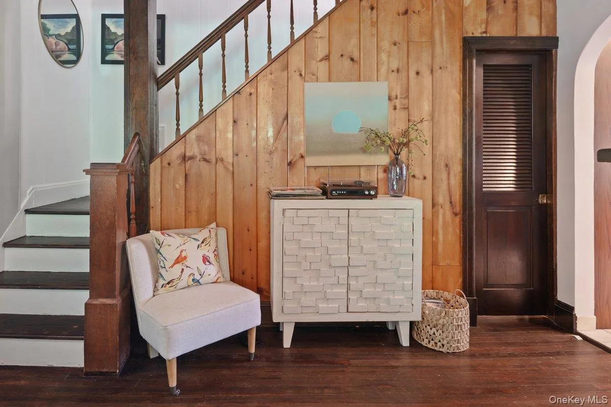 The original wood staircase to second floor is complemented by a natural wood accent wall, and the basement is accessed through a wood pocket door. The original wood staircase to second floor is complemented by a natural wood accent wall, and the basement is accessed through a wood pocket door.