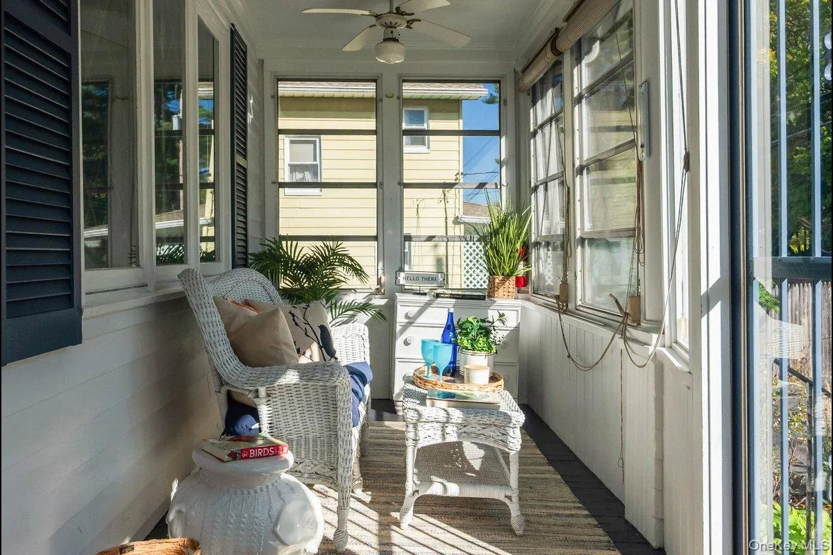 Walls of windows, double ceiling fans, and plenty of room for seating are highlights in the front sun porch. Walls of windows, double ceiling fans, and plenty of room for seating are highlights in the front sun porch.
