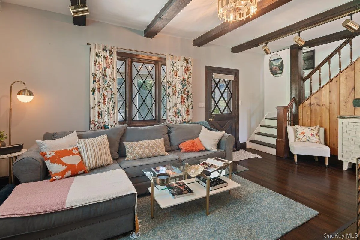 As you enter the home, you are immediately greeted by original charm and character, with exposed wood ceiling beams, hardwood floors, diamond-pane windows, an original staircase with wood paneling, and modern updates featuring track lighting and a novelty chandelier. As you enter the home, you are immediately greeted by original charm and character, with exposed wood ceiling beams, hardwood floors, diamond-pane windows, an original staircase with wood paneling, and modern updates featuring track lighting and a novelty chandelier.