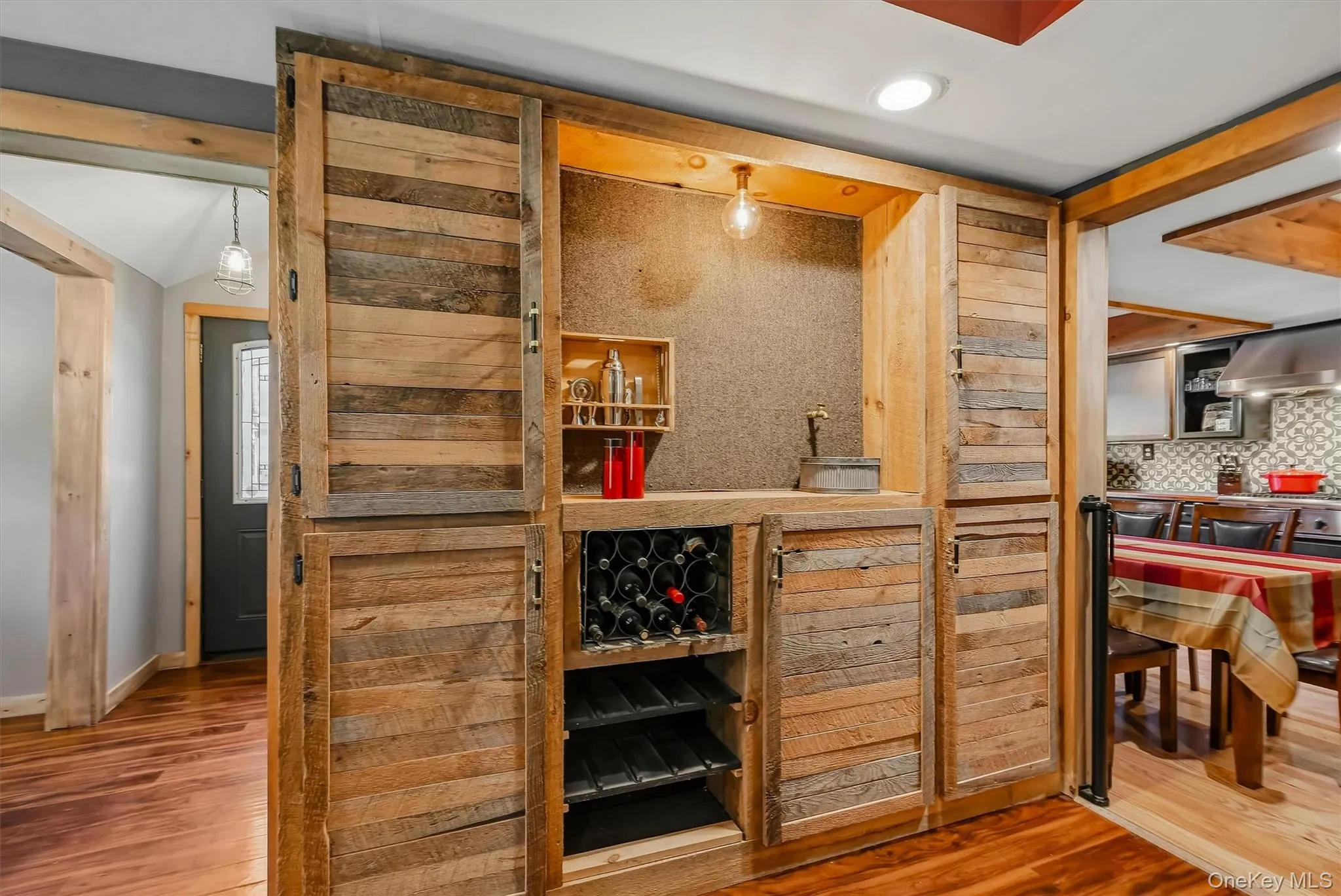 Built-in cabinetry with wood-finish panels, integrated wine rack, recessed lighting, and a prominent wood-beam ceiling accent Built-in cabinetry with wood-finish panels, integrated wine rack, recessed lighting, and a prominent wood-beam ceiling accent