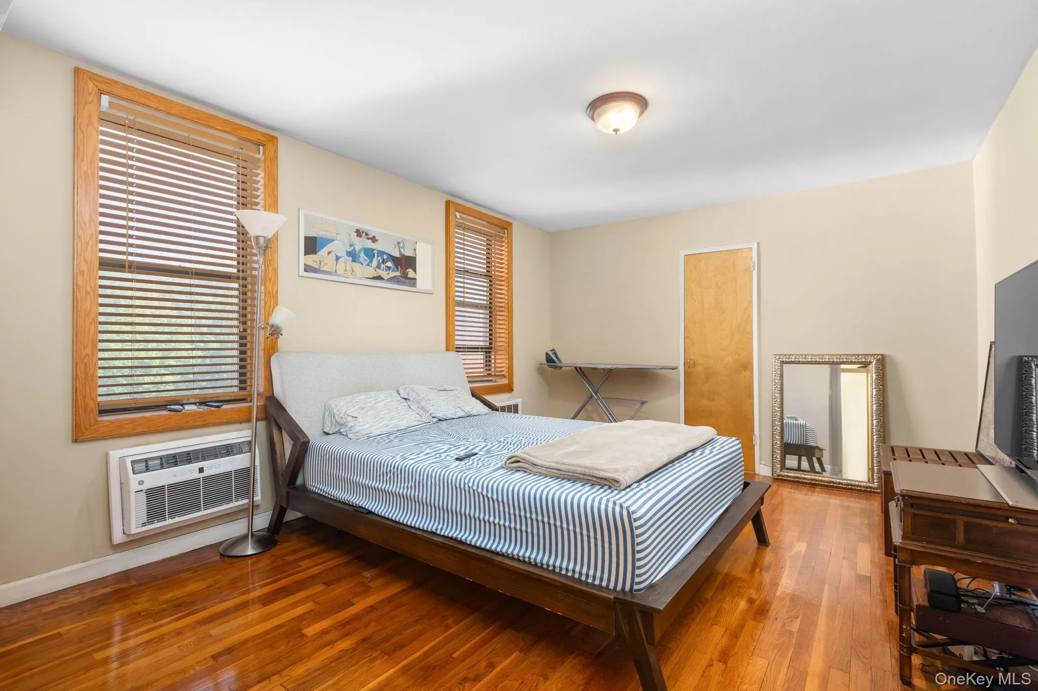 Hardwood flooring, light-toned walls, and wood-framed windows with blinds Hardwood flooring, light-toned walls, and wood-framed windows with blinds