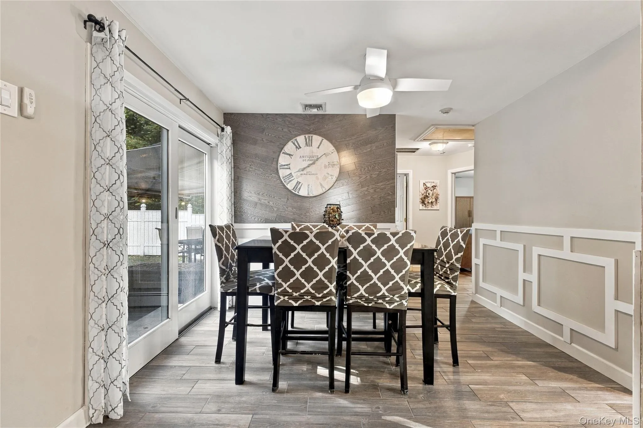 Dining area with ceramic tile foor, wainscoting, sliders to patio and ceiling fan Dining area with ceramic tile foor, wainscoting, sliders to patio and ceiling fan