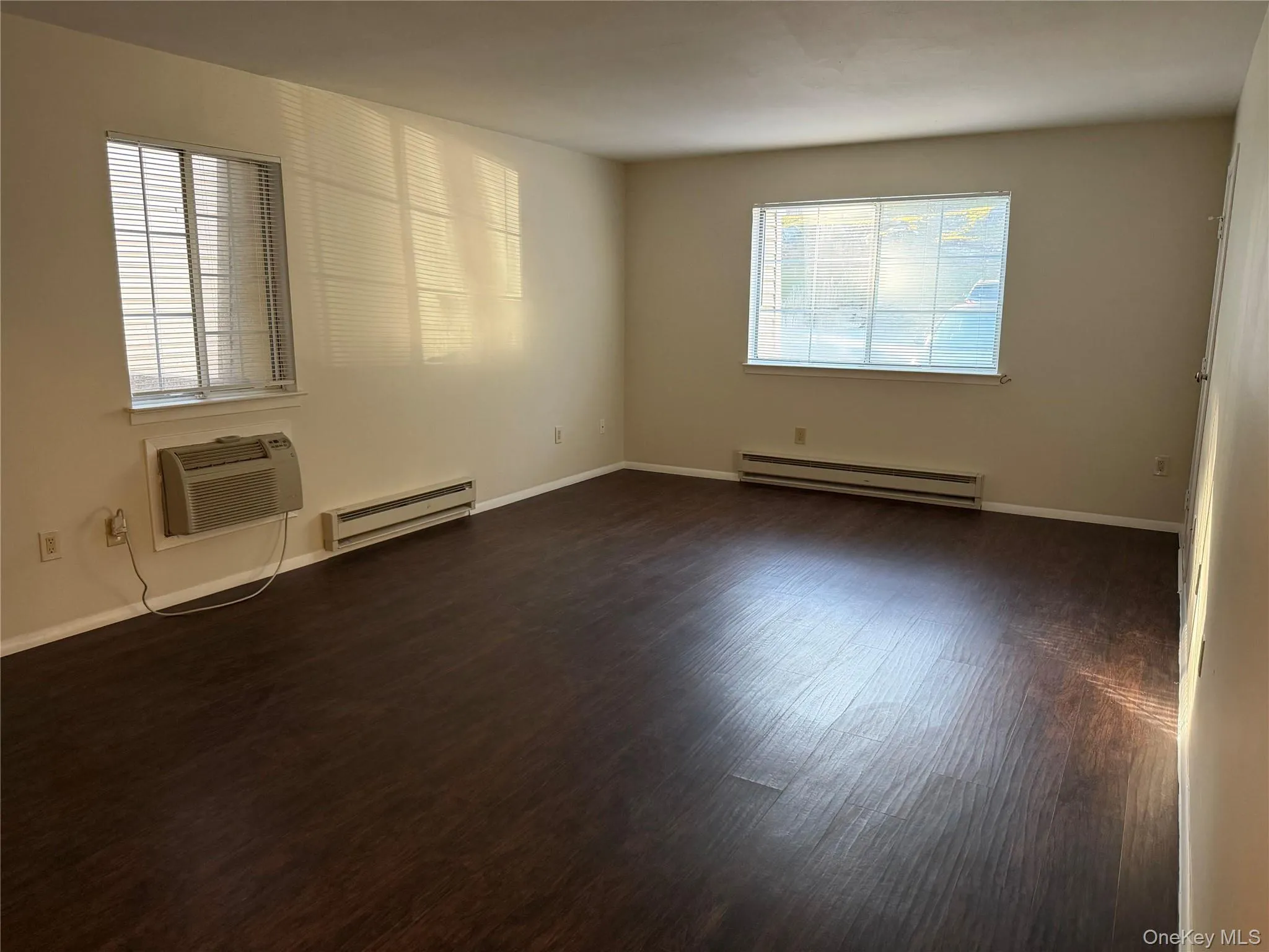 Hard-surface flooring, multiple windows, and a wall-mounted air conditioning unit. Hard-surface flooring, multiple windows, and a wall-mounted air conditioning unit.