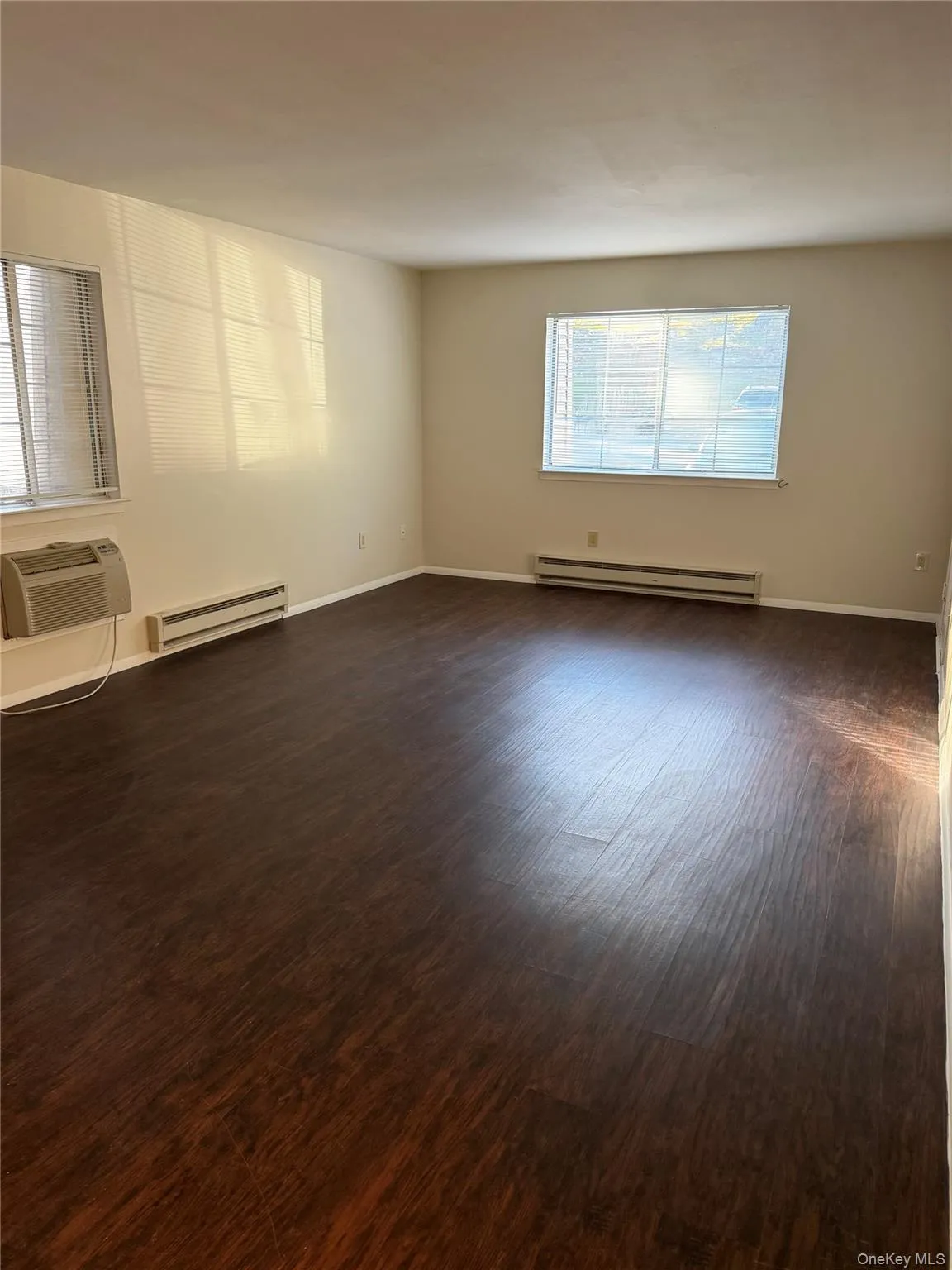 Wood-finish flooring throughout, multiple windows with blinds, and neutral wall tones. Wood-finish flooring throughout, multiple windows with blinds, and neutral wall tones.