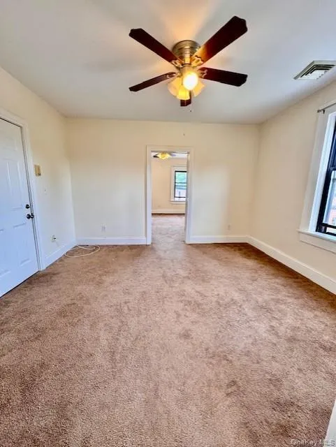 Unfurnished room featuring a ceiling fan and carpet Unfurnished room featuring a ceiling fan and carpet