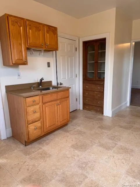 Kitchen featuring brown cabinets and dark countertops Kitchen featuring brown cabinets and dark countertops