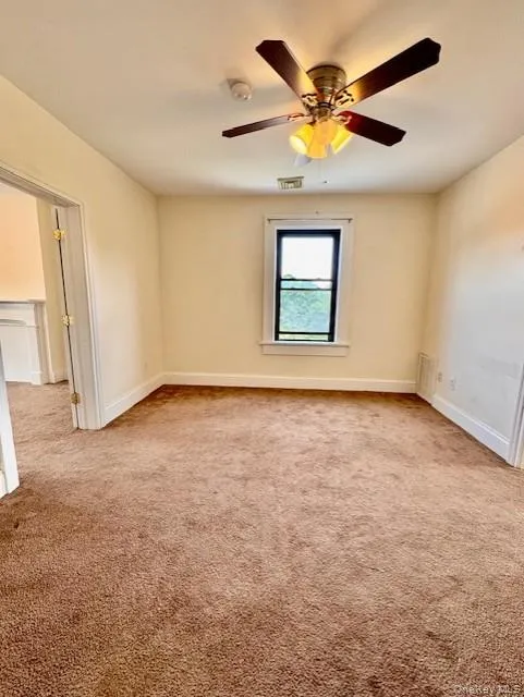Unfurnished room with carpet, a smoke detector, and a ceiling fan Unfurnished room with carpet, a smoke detector, and a ceiling fan