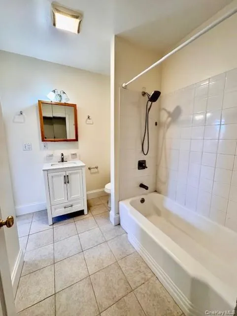 Bathroom with tile patterned floors, shower / bathtub combination, and vanity Bathroom with tile patterned floors, shower / bathtub combination, and vanity