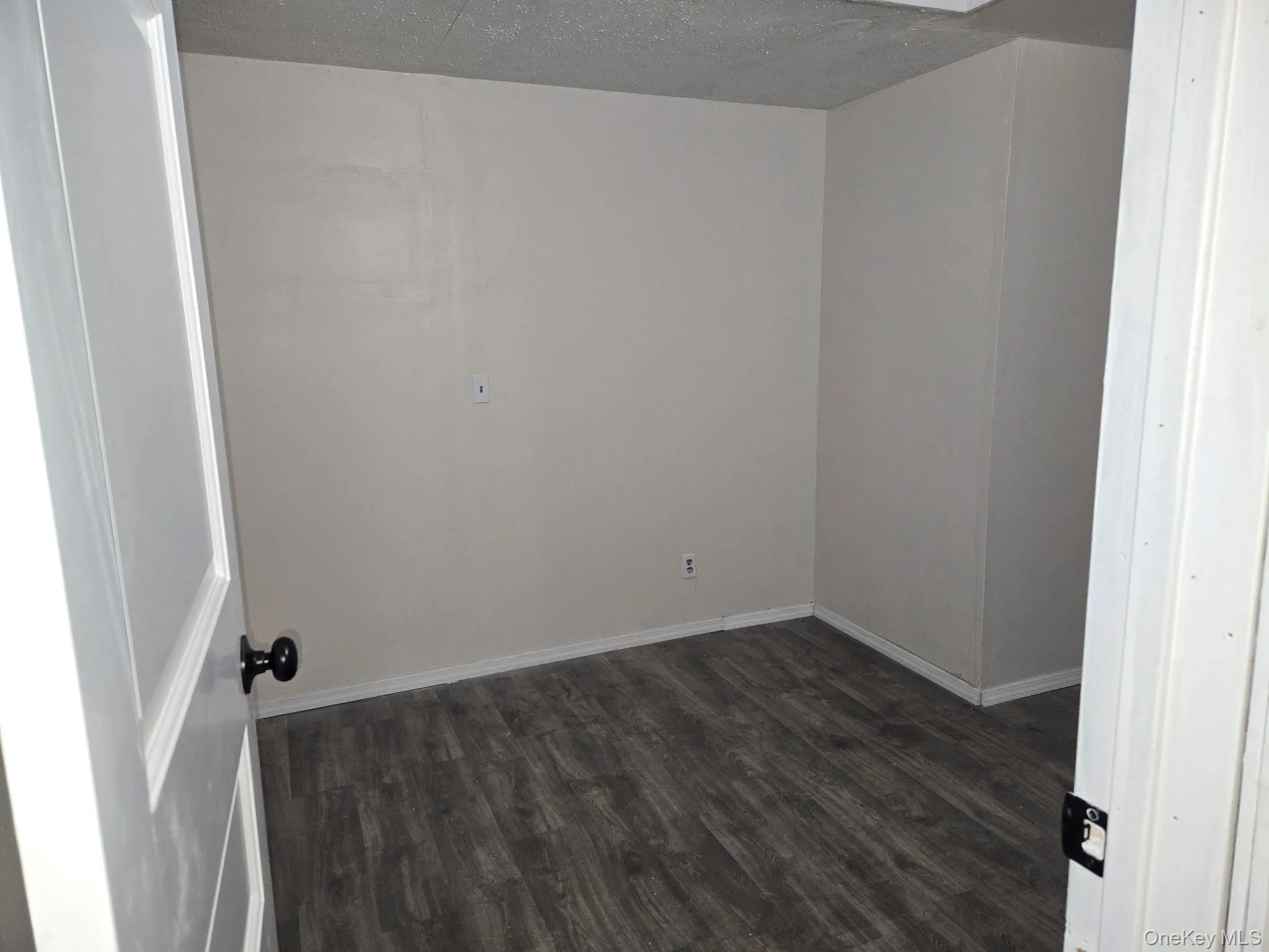 Bedroom featuring dark wood-style flooring and a textured ceiling Bedroom featuring dark wood-style flooring and a textured ceiling