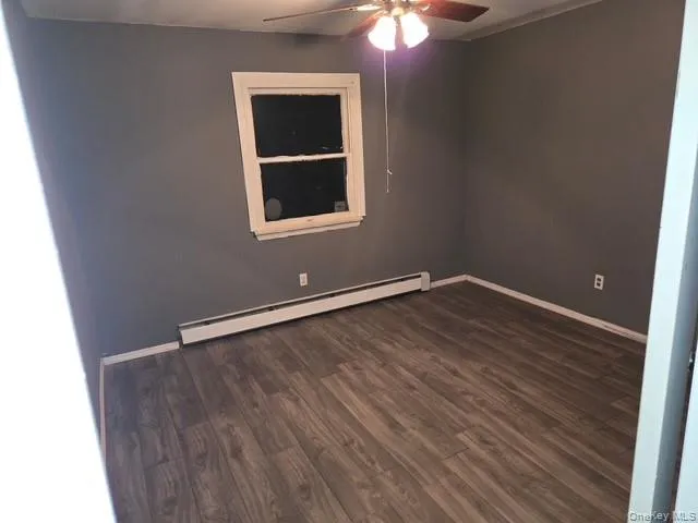 Bedroom with dark wood finished floors, a baseboard radiator, and ceiling fan Bedroom with dark wood finished floors, a baseboard radiator, and ceiling fan