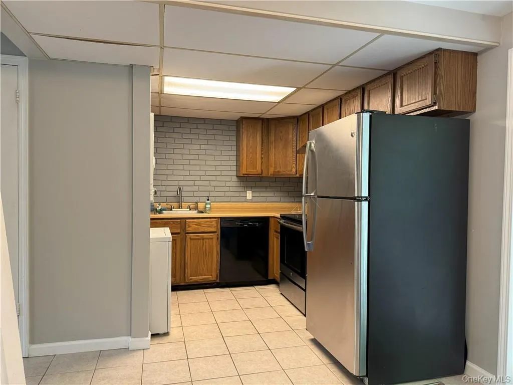 Eat-In Kitchen featuring appliances with stainless steel finishes, tasteful backsplash, sink, a drop ceiling, and light tile patterned flooring Eat-In Kitchen featuring appliances with stainless steel finishes, tasteful backsplash, sink, a drop ceiling, and light tile patterned flooring