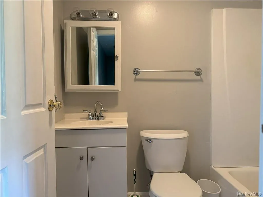 Full bathroom with vanity, washtub / shower combination, and toilet Full bathroom with vanity, washtub / shower combination, and toilet