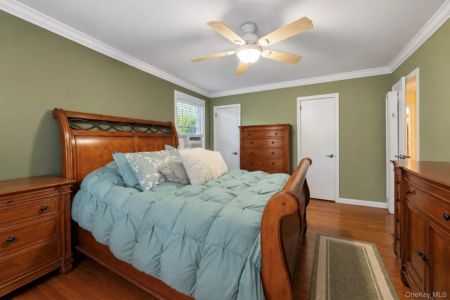 Interior space featuring wood-finish flooring, crown molding, and a central ceiling fan with an integrated light fixture Interior space featuring wood-finish flooring, crown molding, and a central ceiling fan with an integrated light fixture