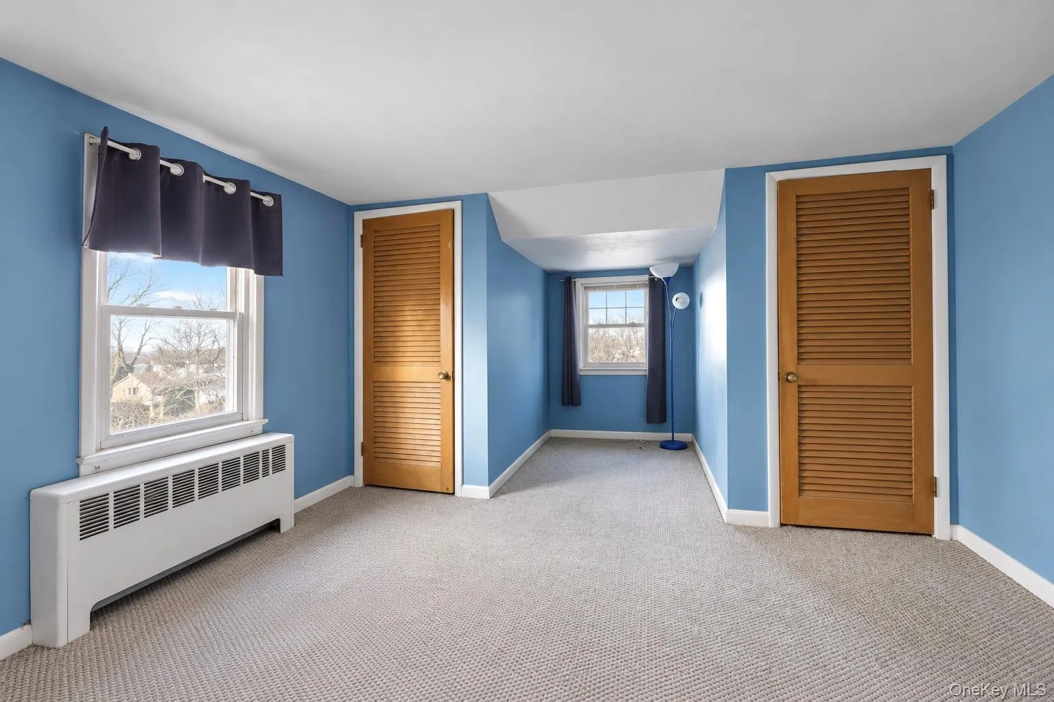 Neutral carpeting, double-hung windows, and two sets of louvered closet doors Neutral carpeting, double-hung windows, and two sets of louvered closet doors