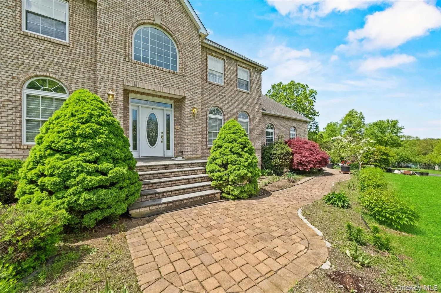 Property entrance with brick siding and a lawn Property entrance with brick siding and a lawn