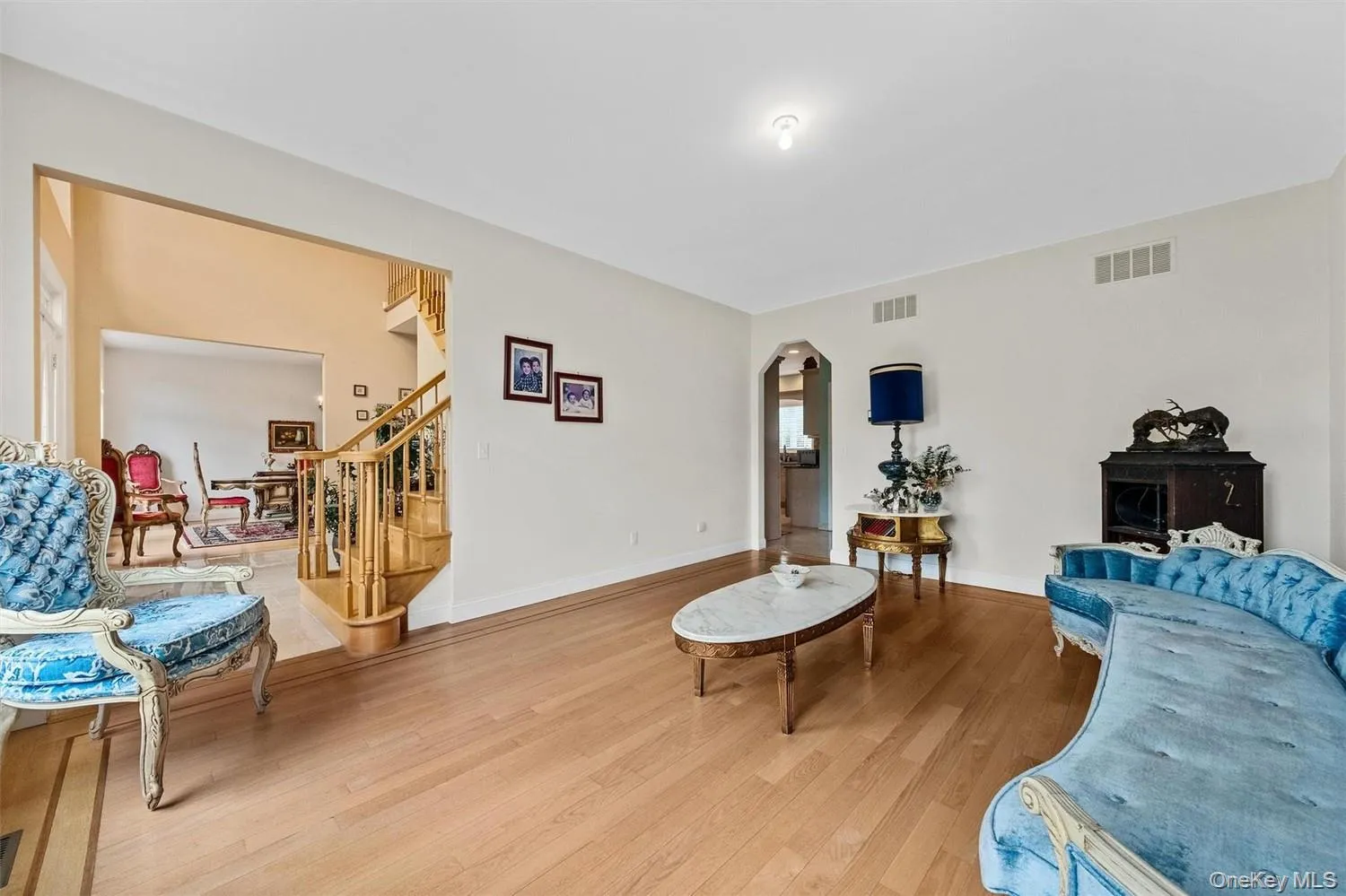 Living room with arched walkways and wood finished floors Living room with arched walkways and wood finished floors