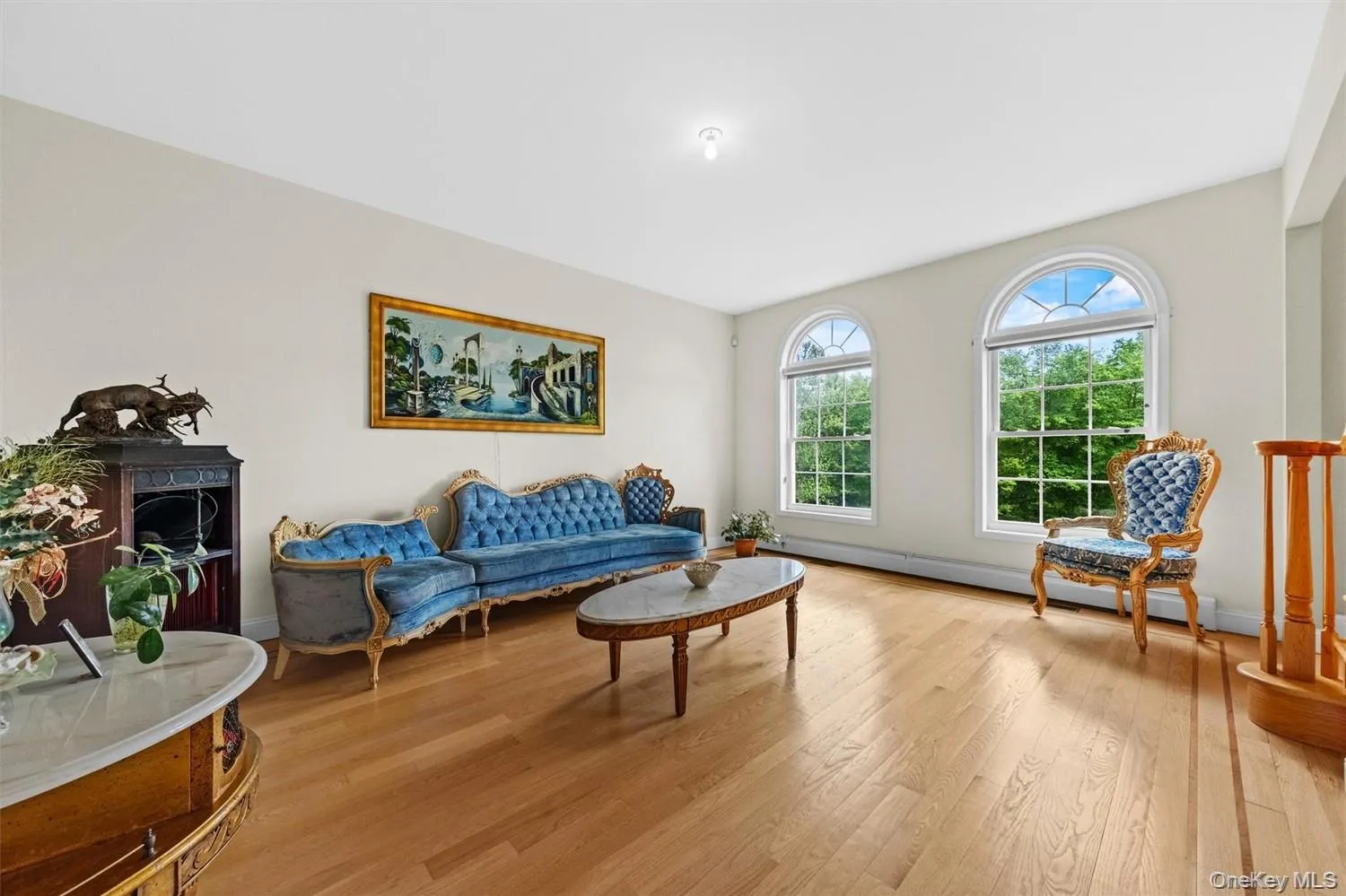 Living area featuring wood finished floors and a baseboard heating unit Living area featuring wood finished floors and a baseboard heating unit