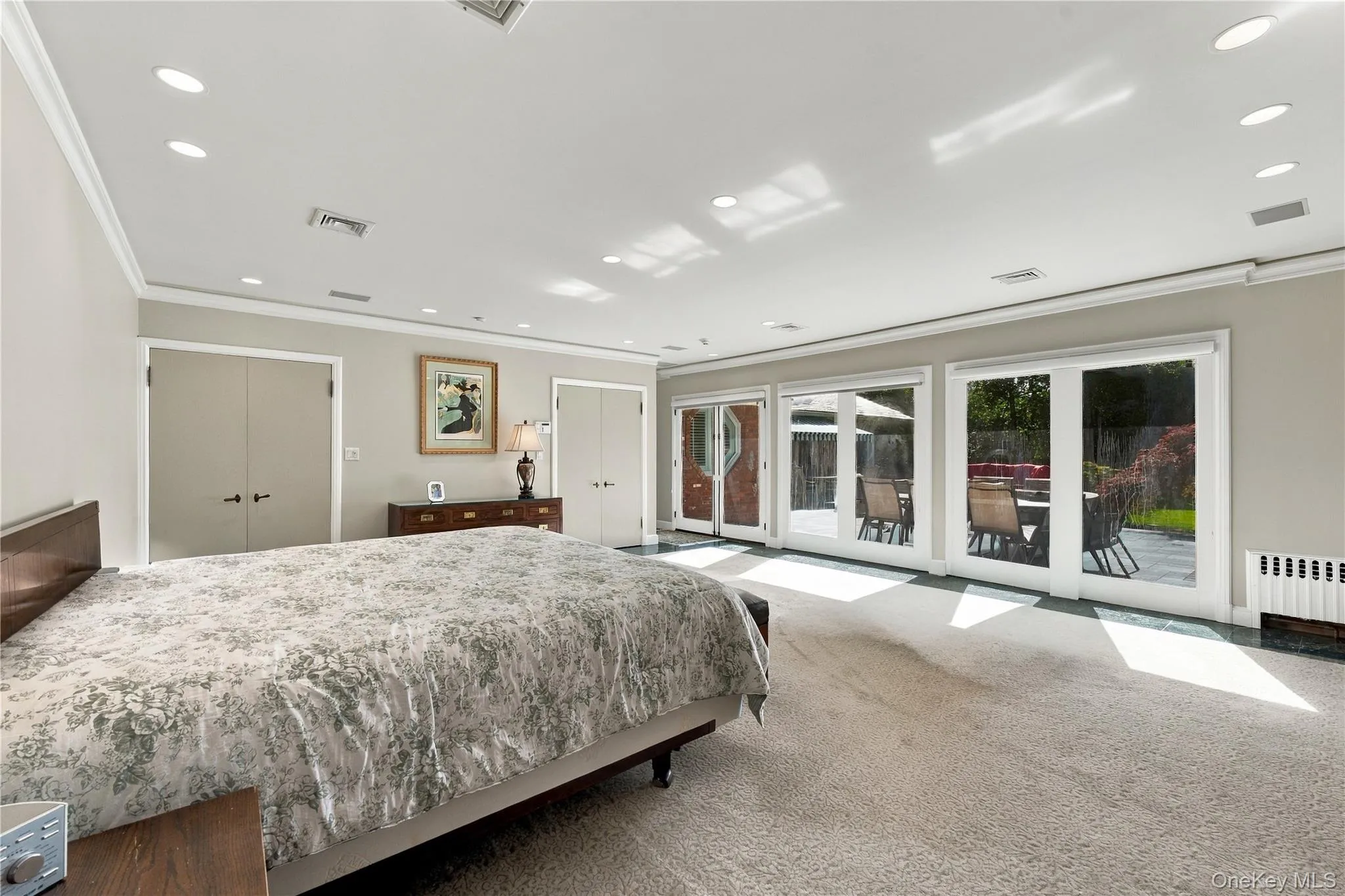 Expansive room featuring recessed lighting, dual closets, and three sets of double glass doors Expansive room featuring recessed lighting, dual closets, and three sets of double glass doors