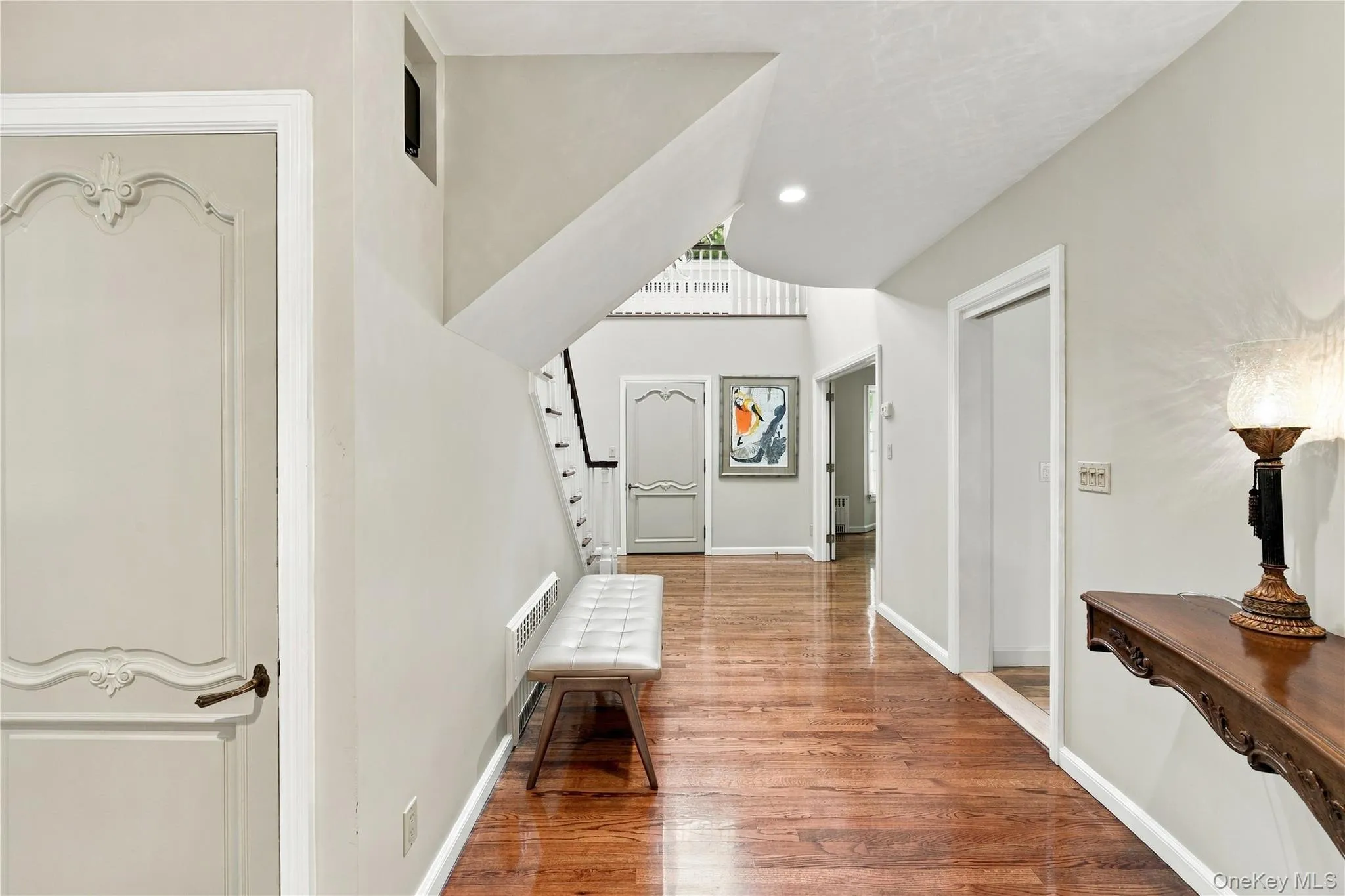 Foyer featuring wood-finish flooring, recessed lighting, and arched-panel interior doors Foyer featuring wood-finish flooring, recessed lighting, and arched-panel interior doors