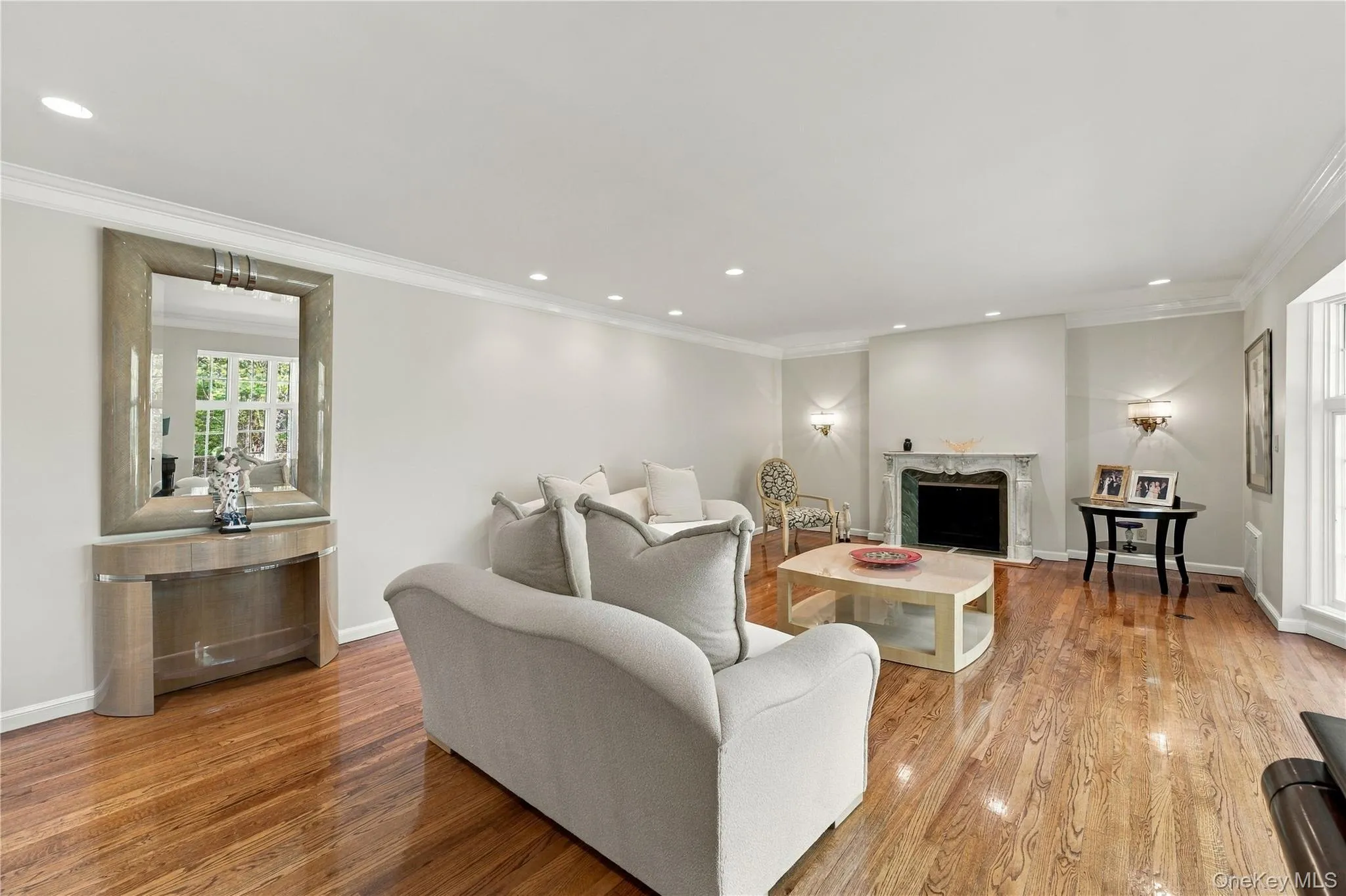 Hardwood flooring, crown molding, recessed lighting, and stone fireplace surround Hardwood flooring, crown molding, recessed lighting, and stone fireplace surround