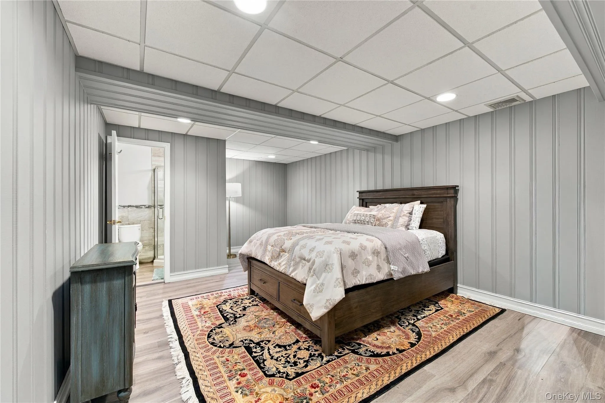 Vertical paneling, wood-finish flooring, recessed lighting, and a drop ceiling Vertical paneling, wood-finish flooring, recessed lighting, and a drop ceiling