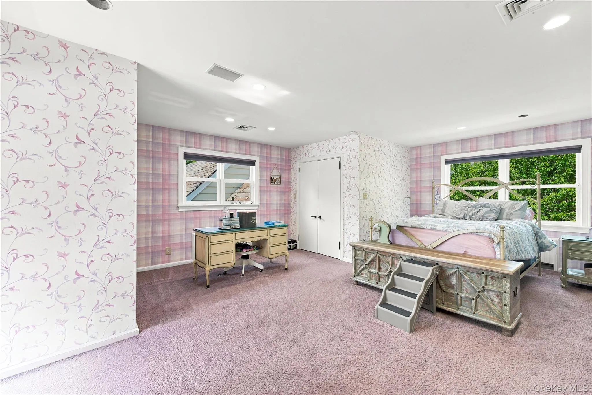 Spacious interior featuring patterned wallpaper, recessed lighting, carpeted flooring, and dual double-pane windows Spacious interior featuring patterned wallpaper, recessed lighting, carpeted flooring, and dual double-pane windows