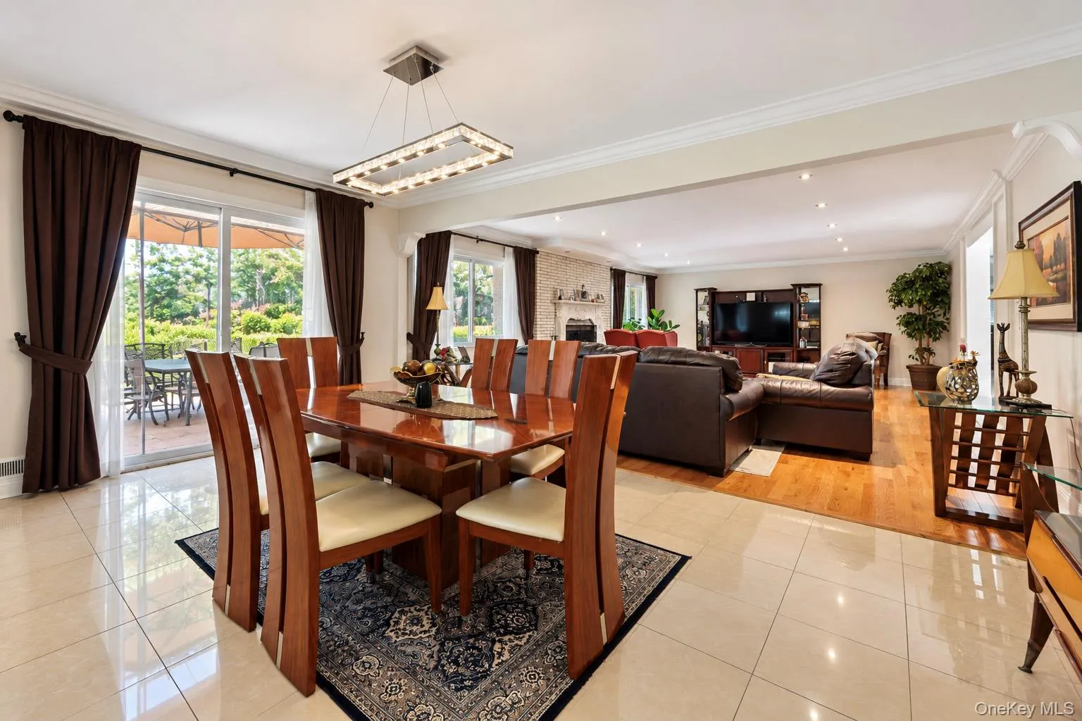 Ceramic tile flooring, crown molding, rectangular multi-light chandelier, and sliding glass doors Ceramic tile flooring, crown molding, rectangular multi-light chandelier, and sliding glass doors