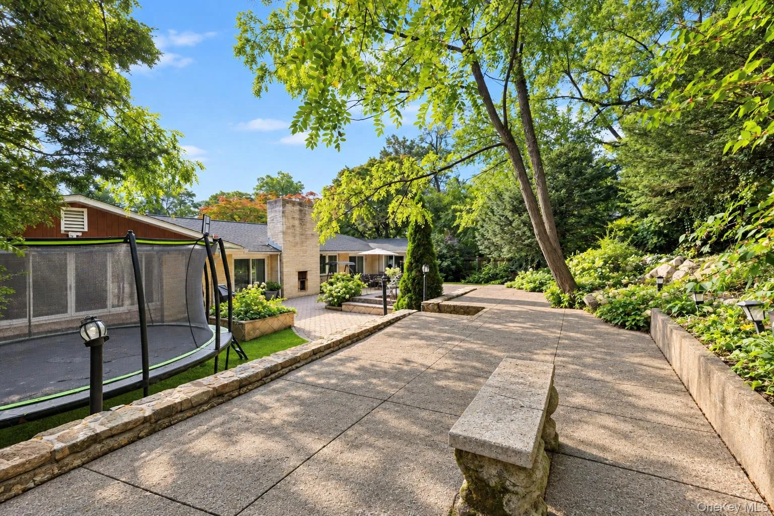 Spacious brick patio featuring a masonry chimney, sliding glass doors, and light-colored brick exterior siding Spacious brick patio featuring a masonry chimney, sliding glass doors, and light-colored brick exterior siding