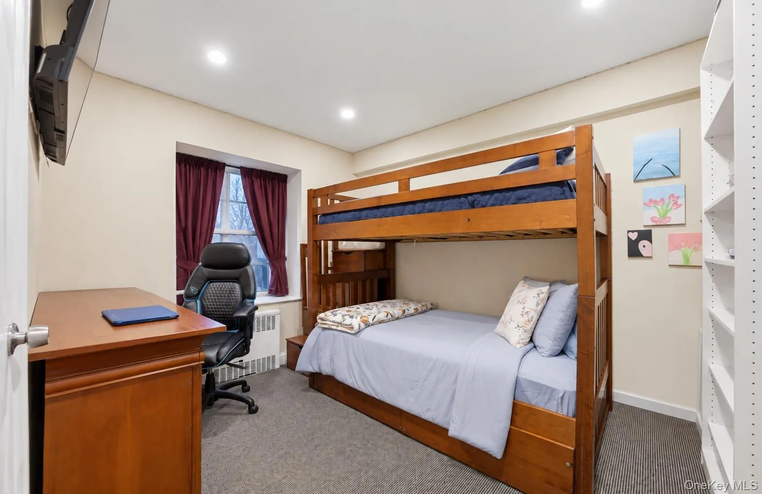 Neutral-toned interior space featuring recessed lighting, wall-to-wall carpeting, and floor-to-ceiling built-in shelving Neutral-toned interior space featuring recessed lighting, wall-to-wall carpeting, and floor-to-ceiling built-in shelving