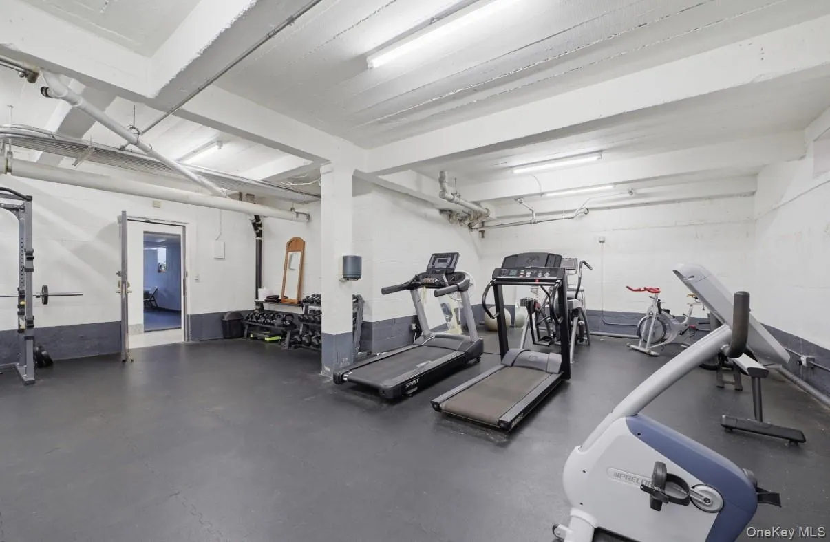 Finished space featuring industrial-style exposed ceiling beams, durable rubberized flooring, and painted masonry walls Finished space featuring industrial-style exposed ceiling beams, durable rubberized flooring, and painted masonry walls