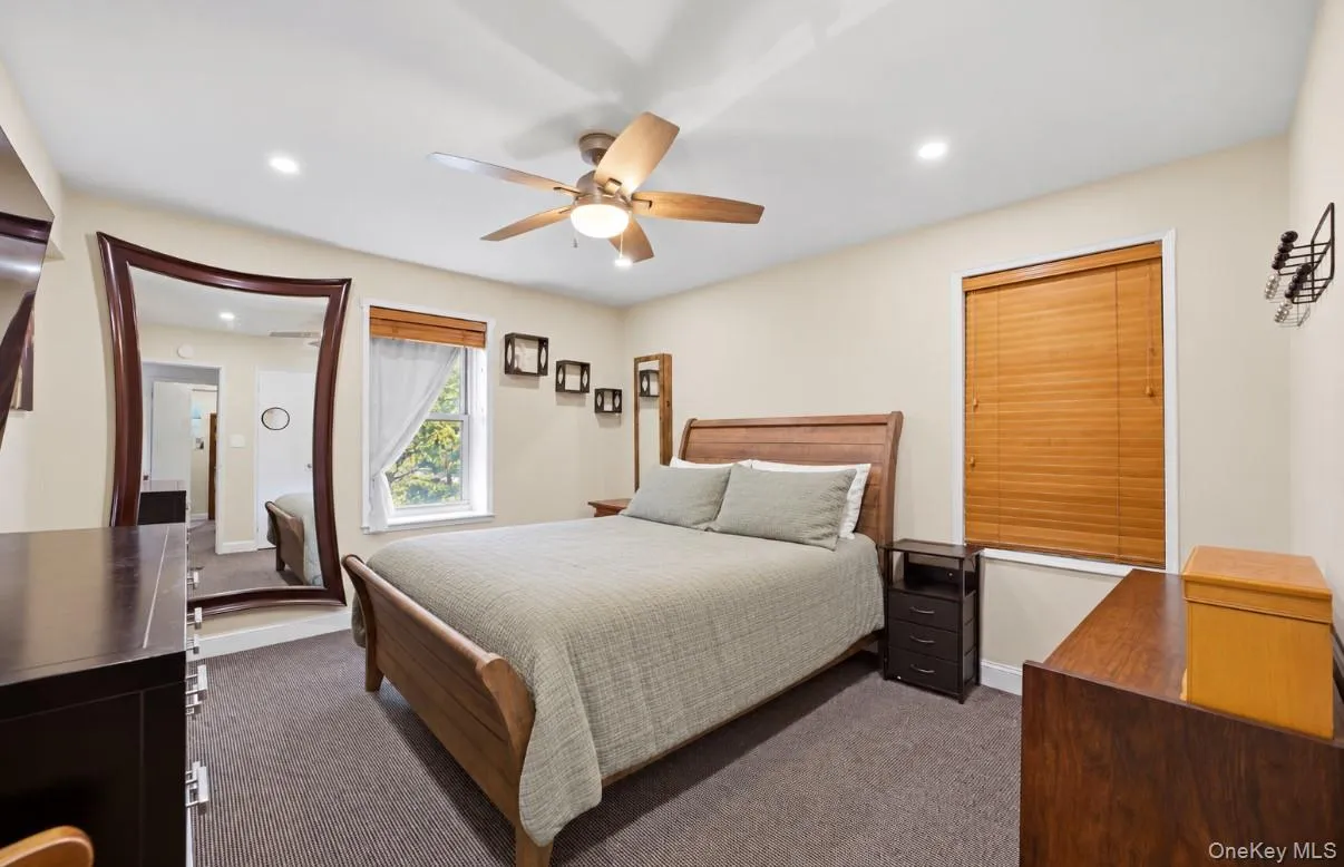 Bedroom featuring a tray ceiling, recessed lighting, ceiling fan, and window treatments Bedroom featuring a tray ceiling, recessed lighting, ceiling fan, and window treatments