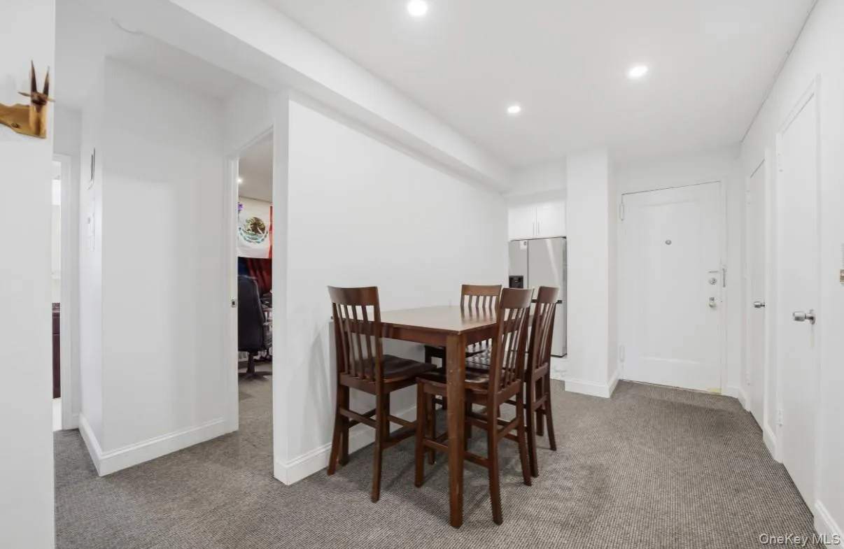 Neutral interior featuring recessed lighting, grey carpeting, crisp white wall finishes, and multiple doorways Neutral interior featuring recessed lighting, grey carpeting, crisp white wall finishes, and multiple doorways