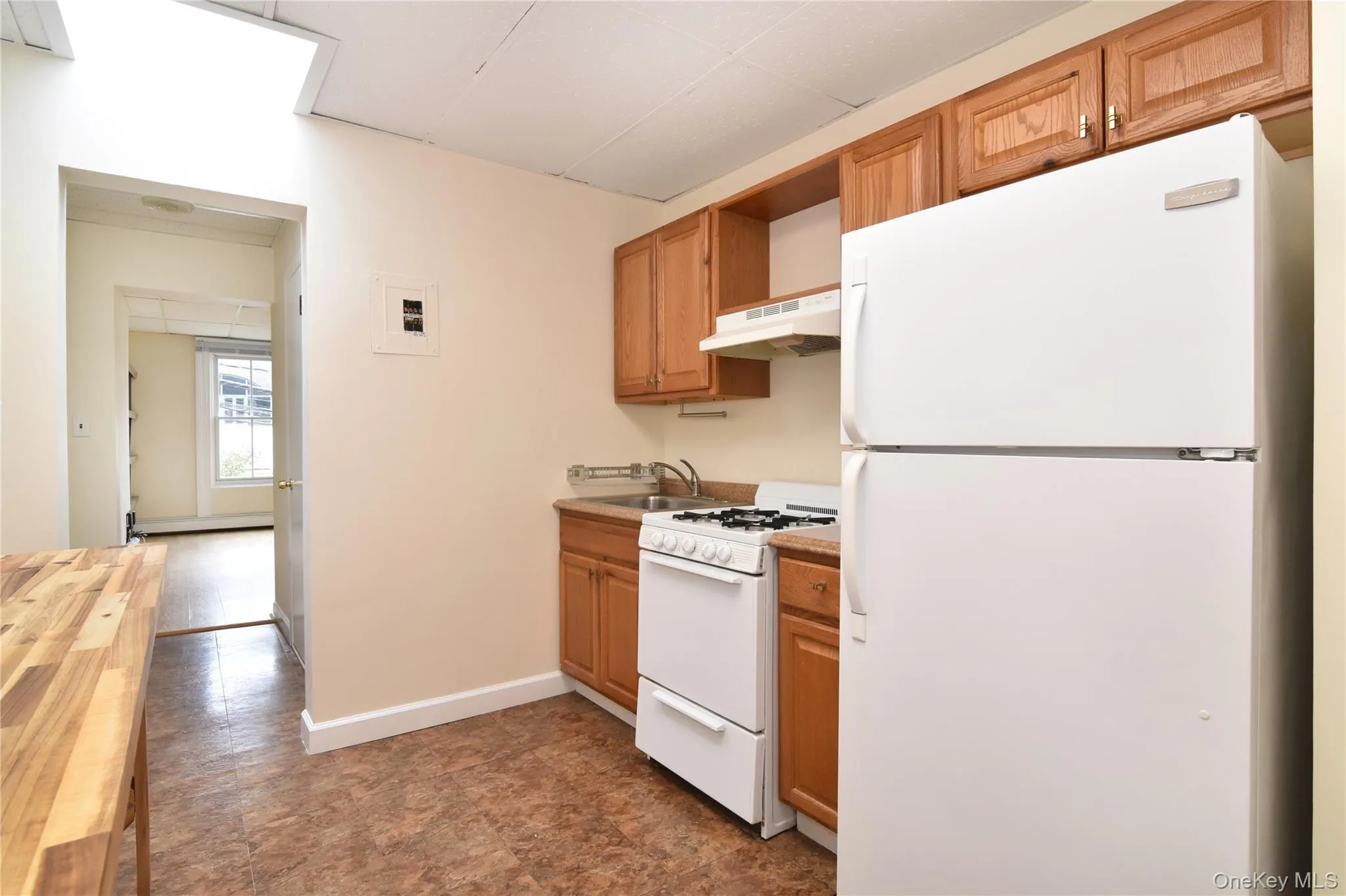 Eat-in Kitchen featuring a skylight window, kitchen appliances, and a butcher block table for more counter space. Eat-in Kitchen featuring a skylight window, kitchen appliances, and a butcher block table for more counter space.